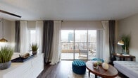 Located in the heart of downtown Memphis, Tennessee, this unit at The Powell offers a thoughtfully designed single-floor layout that balances comfort and urban style. The living area serves as the centerpiece of the space, featuring dark hardwood-style flooring, neutral-toned walls, and floor-to-ceiling sliding glass doors that flood the room with natural light while providing direct access to a private balcony. From the balcony, expansive views of the Memphis skyline create a striking urban backdrop.

The bedroom continues the same hardwood-style flooring and is outfitted with a ceiling fan, large windows, and its own sliding door access to the balcony, reinforcing the airy, light-filled character of the unit. Sheer and layered draping throughout the space adds a refined, contemporary aesthetic.

The kitchen is finished with white shaker-style cabinetry, white quartz countertops, a classic subway tile backsplash, and stainless steel gas appliances, providing a clean and functional cooking environment. The full bathroom includes a shower-tub combination, a vanity with storage, and a mirrored medicine cabinet. Overall, the unit presents a cohesive, modern design well-suited for downtown living.