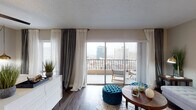 Located in the heart of downtown Memphis, Tennessee, this unit at The Powell offers a thoughtfully designed single-floor layout that balances comfort and urban style. The living area serves as the centerpiece of the space, featuring dark hardwood-style flooring, neutral-toned walls, and floor-to-ceiling sliding glass doors that flood the room with natural light while providing direct access to a private balcony. From the balcony, expansive views of the Memphis skyline create a striking urban backdrop.

The bedroom continues the same hardwood-style flooring and is outfitted with a ceiling fan, large windows, and its own sliding door access to the balcony, reinforcing the airy, light-filled character of the unit. Sheer and layered draping throughout the space adds a refined, contemporary aesthetic.

The kitchen is finished with white shaker-style cabinetry, white quartz countertops, a classic subway tile backsplash, and stainless steel gas appliances, providing a clean and functional cooking environment. The full bathroom includes a shower-tub combination, a vanity with storage, and a mirrored medicine cabinet. Overall, the unit presents a cohesive, modern design well-suited for downtown living.