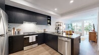 Located at 101 River Park Dr in San Diego's Mission Valley, this well-appointed one-bedroom, one-bathroom residence offers a thoughtfully designed single-floor layout with modern finishes throughout. The open-concept kitchen and living area serves as the heart of the home, where bold dark-ribbed cabinetry contrasts beautifully against white subway tile backsplash and dark stone countertops. Stainless steel appliances, including a gas range, dishwasher, and full-size refrigerator, complete the chef-friendly kitchen. Light wood-tone flooring flows seamlessly throughout the space, enhancing its warm, contemporary aesthetic. The living room is bright and inviting, with large sliding glass doors opening to a private balcony that frames views of lush landscaping. The bedroom is a comfortable retreat, filled with natural light from a generous window overlooking greenery, and features direct access to a dedicated walk-in closet with built-in shelving and hanging storage. The bathroom is elegantly finished with a floating dark wood vanity, dual backlit mirrors, stone-topped counters, and clean white walls that create a spa-like atmosphere. Recessed lighting and light-filled rooms contribute to an airy, modern ambiance throughout this stylish San Diego residence.