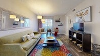 Located at 10201 N 33rd Ave in Phoenix, Arizona, this well-appointed one-bedroom, two-bathroom unit offers a thoughtfully designed single-level layout with wood-look flooring that flows throughout the entire space. The open-concept living area is bright and inviting, with natural light streaming through sliding glass doors that lead to an outdoor area. The living room provides generous space for comfortable seating and includes a textured ceiling, while the adjacent dining area features a ceiling fan and its own window, creating a cozy atmosphere for meals. The galley-style kitchen is equipped with white cabinetry, dark granite-style countertops, black appliances, and a peninsula that connects to a built-in pantry closet — offering ample storage and prep space. The spacious bedroom features the same wood-look flooring, a textured ceiling, and a calm, neutral palette. Two full bathrooms serve the unit; one includes a wide vanity with dark countertops and a walk-through to a separate tub/shower area, while the second features a tub/shower combo. A dedicated closet provides additional storage. The overall ambiance is warm and functional, with cohesive finishes and a practical layout well-suited for comfortable everyday living in Phoenix.