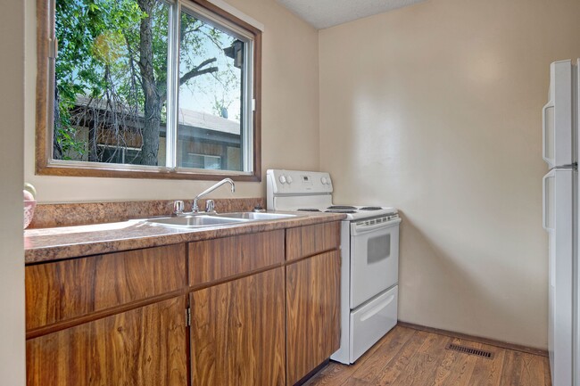 A kitchen with white appliances and dark cabinetry - Ventana