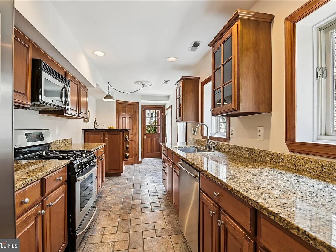 Large kitchen with granite countertops and breakfast bar. - 512 S Washington St