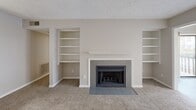 This 1090 square foot apartment in Raleigh, NC offers a perfect blend of comfort and functionality. The space features two bedrooms, including a primary bedroom of 160 square feet, and an impressive four bathrooms. The modern kitchen is a highlight, boasting white cabinetry, stainless steel appliances, and ample counter space. The living area is warm and inviting, centered around a fireplace flanked by built-in shelving. Plush carpeting in the bedrooms and living spaces adds comfort, while the kitchen and bathrooms feature easy-to-maintain wood-look flooring. A private balcony provides a tranquil outdoor space, overlooking a wooded area that offers both privacy and natural beauty. The apartment's neutral color palette and abundance of natural light create a bright, airy atmosphere throughout. With its thoughtful layout and generous amenities, this apartment offers a perfect balance of style and practicality for comfortable modern living.