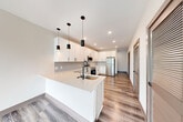 Located at 555 Boulevard NE in Atlanta's vibrant Old Fourth Ward neighborhood, this thoughtfully designed 2-bedroom, 2-bathroom residence offers a clean, contemporary aesthetic throughout. The open-concept kitchen anchors the living space with sleek white cabinetry, quartz countertops, a large peninsula with an integrated sink, stainless steel appliances, and stylish pendant lighting — all set atop warm wood-look luxury vinyl plank flooring. The living area is bathed in natural light, featuring a ceiling fan and full glass French doors that open directly onto a generous private balcony with sweeping views of Atlanta's lush tree canopy and city skyline. The primary bedroom offers comfortable carpeted flooring, a ceiling fan, a double sliding-door closet, and direct access to the en-suite bath. The second bedroom also features plush carpet, a ceiling fan, and a bright window. Both bathrooms are finished with white vanities, quartz counters, marble-look tile flooring, and matte black fixtures. Additional details include louvered interior doors, dark-trimmed panel doors, and recessed lighting throughout, giving the space a cohesive, modern character from every angle.