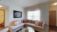 Located at 4333 Parkway Village Dr in Grove City, Ohio, this single-floor residence offers a practical and comfortable living environment. The living room serves as the heart of the home, featuring a textured ceiling that adds subtle architectural character to the space. A generously sized window dressed with sheer curtains and horizontal blinds allows natural light to fill the room, creating a bright and airy atmosphere. The neutral-toned walls provide a versatile backdrop that complements a range of interior styles. The living area is well-proportioned, offering ample space for seating and everyday living. The decorative ceiling texture adds a classic touch overhead, while the overall layout feels open and functional. Natural light plays a key role in the ambiance of this space, with the window serving as a central feature that connects the interior to the outdoors. The single-floor layout ensures ease of movement throughout the home, making it an accessible and convenient living arrangement. Overall, this residence in Grove City combines practical design with comfortable, light-filled interiors suitable for a variety of lifestyles.