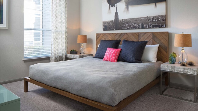 Spacious apartment bedroom with carpeted floors. - Bridge at Soco Crossing