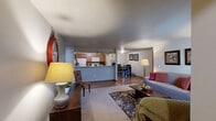 Located at 911 E Beacon Ave in Spokane, WA, this single-floor, 2-bedroom, 2-bathroom home offers a practical and comfortable layout with warm, neutral tones throughout. The kitchen features wood-toned cabinetry, tile backsplash, laminate countertops, hardwood-style flooring, and full white appliances including a range, microwave, and refrigerator. It opens directly into a dedicated dining room with hardwood-style flooring, providing a clear separation between cooking and dining spaces. The living room is carpeted and filled with natural light from a large window, creating a welcoming and relaxed atmosphere. The spacious primary bedroom offers generous room to furnish comfortably, with a window for natural light, plush carpet, and access to a dedicated closet equipped with built-in wood shelving and hanging rods. The second bedroom is similarly carpeted with neutral walls and a textured ceiling. Both bathrooms are well-appointed; one features a full tub-shower combo with a large vanity mirror, wood cabinetry, and tile-accented countertops, while the second includes hardwood-style flooring and baseboard heating. Throughout the home, warm wood-toned doors and trim add a cohesive, classic character to the overall design.