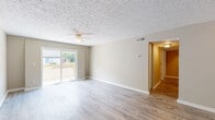 Located at 6810 Brooklawn Dr in Louisville, KY, this 2-bedroom, 1-bathroom residence offers a thoughtfully designed single-floor layout with consistent modern finishes throughout. Light wood-look flooring flows seamlessly across all living areas, complemented by neutral warm-beige walls and textured ceilings that create a cohesive, inviting atmosphere.

The galley-style kitchen is well-equipped, featuring white shaker cabinetry with brushed nickel hardware, light marble-pattern countertops, a stainless steel refrigerator, and a black electric range. Light wood flooring continues here, adding warmth to the functional workspace.

The spacious living room is bathed in natural light from a sliding glass door that opens to an outdoor patio, and is further enhanced by a ceiling fan overhead. Both bedrooms offer comfortable proportions, each with large windows that allow natural light to filter in, along with sizable bi-fold closets providing ample storage. The primary bedroom is generously sized and connects easily to the hallway.

The full bathroom is finished with marble-look tile flooring, a gray vanity with mirror, Hollywood-style lighting, and a full tub-shower combination. A connecting hallway ties all rooms together, completing this clean, move-in-ready home.