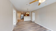 Located at 6306 Old Mooretown Rd in Williamsburg, Virginia, this two-bedroom, two-bathroom residence offers a practical and comfortable single-floor layout. The open-concept living and kitchen area forms the heart of the home, where durable hardwood-style flooring, neutral warm-toned walls, and ceiling fans create a bright and welcoming atmosphere. The kitchen is well-appointed with dark espresso cabinetry, granite-style countertops, stainless steel appliances including a French door refrigerator and electric range, and a peninsula with a double sink that opens to the living space — ideal for both cooking and entertaining. Natural light pours into the living room through a glass door, adding to the airy feel of the space. The primary bedroom is generously sized with plush carpeting, a ceiling fan, and windows that bring in ample daylight. The second bedroom mirrors this comfortable aesthetic. Each bathroom is clean and functional, with one featuring a modern floating vanity, sleek tile flooring, and contemporary lighting. Two dedicated closets provide practical storage solutions throughout. The overall design is cohesive and move-in ready, offering a comfortable lifestyle in a well-maintained Williamsburg community.