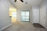 This single-floor residence offers a thoughtfully designed layout with a comfortable blend of functional spaces and modern updates. The living area serves as a welcoming focal point, featuring plush carpeting, a ceiling fan, and a corner fireplace with a tiled surround and white mantel — an ideal spot for relaxing. The kitchen is well-equipped with crisp white cabinetry, dark countertops, stainless steel appliances including a gas range and refrigerator, and a range hood, creating a clean and practical cooking environment. The primary bedroom is generously proportioned with soft carpeting, a window allowing natural light, and direct access to a walk-in closet and an en-suite bathroom. The en-suite features a tiled shower-tub combination, a dark-countered vanity, and bright vanity lighting above a large mirror. A second bedroom offers ample natural light through multiple windows and plush carpet underfoot. The second full bathroom mirrors the updated finishes found throughout, with a shower-tub combo, sleek fixtures, and wood-look flooring. Neutral gray tones on the walls, textured ceilings, and wood-look flooring in the entry and wet areas tie the overall aesthetic together cohesively.
