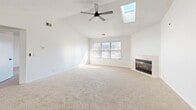 This single-floor unit offers a thoughtfully organized layout across a comfortable footprint, combining functional design with bright, neutral interiors. The living room serves as the central gathering space, featuring plush carpeting, vaulted ceilings that add a sense of openness, and a sliding glass door that opens onto a private balcony with outdoor views — allowing natural light to fill the room throughout the day.

The galley-style kitchen is efficiently designed with light wood-tone flooring, white cabinetry with matte black hardware, stone-look countertops, and stainless steel appliances. A pass-through counter connects the kitchen to the living area, creating an open, communicative flow between spaces. The kitchen also provides direct access to the bathroom.

The spacious primary bedroom features carpet flooring, a large window that invites generous natural light, and direct access to the hallway. Dedicated closet space with built-in shelving provides practical storage solutions.

The bathroom includes a white vanity with an integrated sink, matte black fixtures, and mirrored medicine cabinets, maintaining the clean, cohesive aesthetic found throughout the unit. Two hallways connect the rooms efficiently, completing this well-structured and bright single-level layout.