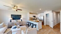 Located at 4118 Hobblebush Dr in Leland, NC, this well-designed two-story home offers three bedrooms and three bathrooms across two thoughtfully laid-out floors. The main level opens into a bright, airy living area bathed in natural light from large windows, with a ceiling fan overhead and light wood-look flooring throughout. The kitchen is a standout feature, showcasing crisp white cabinetry, granite countertops, stainless steel appliances including a French door refrigerator and range, and a central island with bar seating — seamlessly connecting to the dining and living areas. A pantry and attached garage add everyday convenience. Upstairs, the primary bedroom is a comfortable retreat with a ceiling fan, plush carpet, and natural light from neighboring windows. A spacious walk-in closet with wire shelving provides ample storage. Two additional bedrooms share the upper floor, each carpeted and well-lit. The three bathrooms include a sleek glass-door standing shower and a full tub-shower combo. A dedicated laundry room with a full-size washer and dryer rounds out the upper level. With six closets and multiple hallways, storage and circulation are well addressed throughout the home.