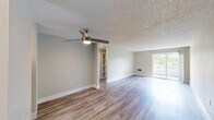 Located in Aloha, Oregon, this 2-bedroom, 1-bathroom single-floor residence offers a practical and well-appointed layout with a clean, neutral aesthetic. Light-toned luxury vinyl plank flooring flows throughout the entire home, complemented by crisp white baseboards and soft beige walls that create a bright, cohesive atmosphere. Textured ceilings add a classic touch to every room.

The kitchen is a standout feature, showcasing white shaker-style cabinetry with brushed nickel hardware, dark granite countertops with a mosaic tile backsplash, and stainless steel appliances including a refrigerator, range, and dishwasher. A window above the sink brings in natural light, enhancing the galley-style layout.

The open living area provides a generous, versatile space with room for multiple furniture configurations. Both bedrooms are comfortably sized, each featuring windows with blinds that offer views of surrounding greenery. The primary bedroom includes a closet with panel doors, while the secondary bedroom features a wall-mounted HVAC vent for year-round comfort.

The bathroom is efficiently designed with a white vanity, dark countertop, and a full tub-shower combo. The home's straightforward single-floor layout ensures easy navigation throughout.