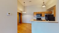 Located at 933 Megan Ln in Willard, Missouri, this single-floor unit offers a well-designed layout with a cohesive blend of functional and comfortable living spaces. The open-concept kitchen and living area is immediately impressive, featuring soaring vaulted ceilings that amplify the sense of space. The kitchen is equipped with warm honey-toned wood cabinetry, black appliances including a range, built-in microwave, refrigerator, and dishwasher, along with a peninsula breakfast bar with a light countertop that serves as a natural divider between the kitchen and living areas. Elegant pendant lighting illuminates both sides of this shared space. Light hardwood flooring flows throughout the main living and kitchen areas, adding warmth and continuity. The bedrooms are generously sized, each featuring ceiling fans with integrated lighting and windows dressed with blinds that allow for ample natural light. One bedroom offers direct access to an exterior door, providing added convenience. Carpeted flooring in at least one bedroom adds a cozy touch. The bathrooms include full tub-shower combinations with clean, white surrounds. Throughout the unit, warm wood-trimmed doorways and baseboards provide a consistent and polished finishing detail.