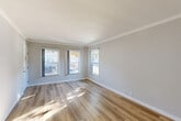 Located in the Hyde Park neighborhood of Los Angeles, this single-floor, 2-bedroom, 1-bathroom home offers a clean, modern aesthetic throughout. The living area is bright and open, featuring warm wood-look flooring, soft gray walls, crown molding, and multiple windows that invite generous natural light. A built-in wall niche adds a thoughtful architectural detail to the living space.

The galley-style kitchen is well-appointed with rich dark cabinetry, white quartz countertops, stainless steel appliances including a full-size refrigerator, and a separate exterior door — providing both functionality and convenience.

The spacious primary bedroom comfortably accommodates large furnishings and includes a ceiling fan, a window for natural light, and a dedicated closet. The second bedroom, also with a ceiling fan and window, is well-suited for a guest room, home office, or additional sleeping quarters.

The bathroom is finished in a clean, all-white palette with a dark-cabineted vanity topped with white quartz, a combined tub and shower, and a frosted window for privacy and light.

Wood-look flooring flows consistently throughout all rooms, and the hallway connects the layout efficiently. This home offers a polished, move-in ready environment with updated finishes at every turn.