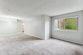This 430 square foot apartment in Seattle offers a thoughtful layout that maximizes every inch of space. The primary bedroom, an impressive 270 square feet, provides ample room for rest and relaxation. The living area features neutral tones with plush carpeting, creating a cozy atmosphere. Large windows allow natural light to flood the space, enhancing the sense of openness.

The kitchen, while compact, is efficiently designed with white cabinetry and durable countertops. A stainless steel sink and modern faucet add a touch of sophistication. The bathroom showcases a contemporary design with marble-look tile surrounding the bathtub and shower combination, complemented by wood-look flooring for warmth.

A standout feature is the in-unit laundry, a rare amenity in apartments of this size. The hallway provides additional storage options. Located at 10500 Meridian Ave N in Seattle, this single-floor unit offers a perfect blend of functionality and comfort in an urban setting.