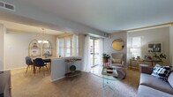 Located at 2813 Route 73 S in Maple Shade, NJ, this single-floor residence offers a thoughtfully laid-out living space with a warm, welcoming ambiance throughout. The living room is a standout area, featuring soft carpeting, neutral-toned walls, and large sliding glass doors that flood the space with natural light and provide direct access to a private outdoor balcony. The open sightlines connect the living area to the dining room, which is anchored by a chandelier and a generous window dressed with blinds and sheer curtains. The galley-style kitchen is efficiently designed with abundant warm-toned wood cabinetry lining both sides, ample counter space, white appliances including a range and refrigerator, a built-in dishwasher, a double sink, and tile flooring. A pass-through window connects the kitchen to the dining area, enhancing the open feel. The two bedrooms are generously proportioned, each finished with plush carpeting, soft neutral paint, and windows that bring in natural light. The full bathroom features a warm wood vanity with a single sink, bright vanity lighting, a large mirror, and classic tile flooring with a cheerful pattern. Throughout the home, a consistent soft color palette and carpeted floors create a cohesive, comfortable atmosphere.
