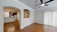 Located at 6595 Lebanon Rd in Frisco, TX, this well-appointed 1-bedroom, 1-bathroom residence offers a thoughtfully designed layout across a single floor. Rich hardwood-style flooring flows throughout the main living areas, complemented by crown molding and ceiling fans that add a polished finish to each room.

The dual living areas are connected by an elegant arched doorway, creating a seamless open feel. The main living room features a tile-surround fireplace, a ceiling fan with light, and multiple windows with sliding glass door access that fill the space with natural light. The second living area transitions smoothly into the kitchen.

The kitchen is equipped with stainless steel appliances — including a range, microwave, and refrigerator — dark cherry cabinetry, a tile backsplash, and granite countertops, delivering both style and functionality.

The bedroom is carpeted for comfort, accented with crown molding and a ceiling fan, and leads directly to a spacious walk-in closet outfitted with wire shelving on multiple levels. The full bathroom includes a combined tub and shower with grab bars, a dark wood vanity, and granite countertop. A dedicated laundry area with side-by-side washer and dryer hookups adds everyday convenience to this well-rounded home.