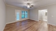 Located in Knoxville, TN, this well-appointed single-story, one-bedroom, one-bathroom home offers a thoughtfully designed layout that maximizes every square foot. The open-concept kitchen and living area serves as the heart of the home, featuring crisp white cabinetry, granite countertops, a shiplap-paneled island with a double sink, stainless steel appliances, and elegant pendant lighting. Light hardwood-style flooring flows throughout the main living spaces, complemented by neutral-toned walls that create a clean, modern aesthetic. Crown molding and a ceiling fan add refined detail to the living room, which is brightened by a large window and a glass-panel exterior door offering outdoor views. The bedroom is a comfortable retreat with its own large window that allows ample natural light and views of the surrounding greenery, along with access to multiple closets for generous storage. The full bathroom features a granite-topped vanity with white cabinetry, a tub-shower combination, and tile flooring. A dedicated laundry room accommodates a full-size washer and dryer. A built-in mudroom area with bench seating and wall hooks provides a practical entryway transition. Three closets throughout the home ensure abundant storage options.