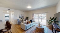 This single-floor unit offers a well-organized layout that includes a living area, dining space, kitchen, two bedrooms, two bathrooms, and a dedicated in-unit laundry area. The living room serves as the central gathering space, finished with warm hardwood-style flooring and a textured ceiling. Large sliding glass doors allow generous natural light to fill the room and provide direct access to a private balcony with outdoor views. A designated dining area sits adjacent, making the combined living and dining space both functional and inviting.

The kitchen is designed with light wood cabinetry, granite-style countertops, and black appliances including an electric range and built-in microwave. A double-door closet provides additional storage within the kitchen area.

Both bedrooms feature plush carpeting and windows with exterior views. The primary bedroom includes an en-suite bathroom with a wood-toned vanity and granite countertop. The second bathroom mirrors this design with a shower-tub combination and matching finishes. Hardwood-style flooring runs through both bathrooms. The in-unit laundry area accommodates a full-sized washer and dryer, adding everyday convenience to this thoughtfully arranged space.