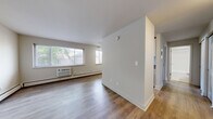 Located at 585 Ellsworth St in Bridgeport, CT, this single-floor, one-bedroom, one-bathroom unit offers a practical and well-designed layout. The living room is bright and open, featuring light hardwood-style flooring, neutral walls, and multiple windows that allow natural light to fill the space. A wall-mounted air conditioning unit and baseboard heating ensure year-round comfort. The bedroom is a comfortable size, continuing the same hardwood-style flooring and neutral color palette, with a large sliding-panel closet providing ample storage. A window with blinds brings in additional natural light. The bathroom is clean and functional, featuring white square wall tiles surrounding a full bathtub and shower combination. A vanity with granite countertops and white cabinetry adds a refined touch, complemented by mosaic tile flooring. Throughout the unit, clean white walls and consistent flooring create a cohesive, move-in-ready aesthetic. The entry area features warm-toned hardwood-style floors and a flush ceiling light, offering a welcoming transition into the living space. This unit combines efficiency and comfort in a straightforward, well-maintained layout.