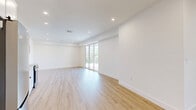 Located at 2134 5th Ave in Troy, NY, this well-appointed 3-bedroom, 2-bathroom residence offers a thoughtfully designed single-floor layout with a clean, modern aesthetic throughout. Light-toned hardwood-style flooring flows seamlessly across the living areas and bedrooms, complementing the crisp white walls and recessed lighting that lend the space a bright, airy feel.

The combined kitchen and living room serves as the heart of the home. The kitchen is outfitted with white shaker-style cabinetry, a white subway tile backsplash, light countertops, and a full suite of stainless steel appliances including a range, microwave, dishwasher, and bottom-freezer refrigerator. Large sliding glass doors in the living area open directly onto a private balcony, which features a composite deck floor and a sleek horizontal metal railing, offering elevated views of the surrounding cityscape and lush tree canopy.

The spacious primary bedroom includes a sliding closet and easy hallway access. The two bathrooms are finished with large-format gray tile flooring — one featuring a soaking tub and the other a glass-enclosed walk-in shower, each with brushed nickel fixtures. Additional rooms include a utility room and a hallway connecting the layout efficiently. The overall ambiance is contemporary, clean, and move-in ready.
