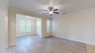 Located at 5001 Ballantyne Drive in Simpsonville, SC, this single-floor, 2-bedroom, 2-bathroom home offers a well-organized and functional layout. The kitchen is equipped with warm-toned wood cabinetry, granite-style countertops, a black appliance suite including a refrigerator, electric range, and microwave, and a peninsula with pendant lighting that opens to the adjacent living area. The living room features light hardwood-style flooring, crown molding, a ceiling fan, and multiple windows that allow natural light and outdoor views to fill the space. The spacious primary bedroom comfortably accommodates large furnishings and is accompanied by a generous walk-in closet with wire shelving for ample storage. The second bedroom also benefits from large windows with natural views. Both bathrooms are finished with tile flooring, wood vanities with granite countertops, and shower-tub combinations. A dedicated laundry room includes washer and dryer hookups and overhead wire shelving. Throughout the home, crown molding, consistent light-toned walls, and hard-surface flooring create a clean, cohesive aesthetic.