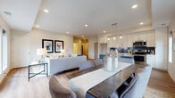 The Willow floor plan at The 85 At Midland Terrace is a thoughtfully designed two-bedroom, two-bathroom residence that balances modern aesthetics with practical functionality. The open-concept living area seamlessly connects the living room, dining space, and kitchen, creating a cohesive and inviting atmosphere. Light wood-style flooring runs throughout the main living areas, complementing the neutral color palette and recessed lighting overhead.

The kitchen is a standout feature, equipped with stainless steel appliances, crisp white shaker cabinetry, a navy blue subway tile backsplash, and a contrasting dark island with pendant lighting above. Generous counter space and ample storage make it both stylish and functional.

The living room benefits from large windows that allow natural light to fill the space and offer outdoor views, while the dining area provides room for a full-sized table. Each bedroom is carpeted and features windows with outdoor views, offering a quiet retreat. The bathrooms are finished with clean tilework and white floating vanities with black hardware accents.

A dedicated in-unit laundry closet with a full-size washer and dryer adds everyday convenience. An additional flexible room provides space adaptable to a home office or sitting area, rounding out this well-appointed residence.