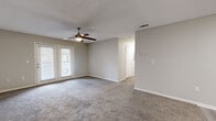 Located at 104 Manson Rd in Sherwood, Arkansas, this single-floor, 2-bedroom, 2-bathroom home offers a functional and well-organized layout. Neutral gray tones throughout the interior create a cohesive, move-in-ready aesthetic.

The living area is spacious and carpeted, featuring a ceiling fan with light fixture and a textured ceiling. French doors provide natural light and access to an outdoor area, enhancing the open feel of the room. A hallway connects the living space to the bedrooms and bathrooms.

The galley-style kitchen features white cabinetry, light wood-look vinyl flooring, stainless steel appliances including a refrigerator and dishwasher, and a built-in sink. A skylight-style overhead fixture brightens the workspace effectively.

Both bedrooms are carpeted and equipped with ceiling fans. The primary bedroom includes direct access to its own bathroom and an additional closet, providing practical storage. The second bedroom features a window with blinds, allowing natural light. Both bathrooms include tub-shower combinations, wood-look vinyl flooring, and clean white finishes, providing a simple and functional design throughout.