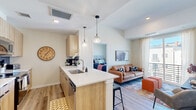 Located at 295 E Las Animas St in Colorado Springs, CO, this thoughtfully designed 2-bedroom, 2-bathroom residence offers a modern, efficient layout across a single floor. The open-concept living and kitchen area serves as the heart of the home, where light wood cabinetry, white quartz countertops, a peninsula with bar seating, and stainless steel appliances—including a full-size refrigerator—come together to create a functional and stylish kitchen. Globe pendant lights add a contemporary touch overhead. The living room features light wood-tone flooring, a sliding glass door that floods the space with natural light, and a private balcony offering views of the Colorado mountain skyline. The primary bedroom is a calm, carpeted retreat with a dedicated closet and easy access to its own bathroom, which includes a tub/shower combination and a wood-toned vanity with white countertop. The second bedroom features a bright window with neighborhood views, making it a versatile space. The second bathroom mirrors the clean aesthetic with a shower/tub combo and matching vanity. Throughout the residence, a cohesive neutral palette, recessed lighting, and warm wood accents create a modern and inviting ambiance well-suited to Colorado living.