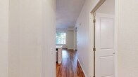 Located at 2551 38th Ave NE in St. Anthony, Minnesota, this single-floor unit offers a thoughtfully designed layout that makes efficient use of its space. Warm hardwood-style flooring runs continuously throughout, lending a cohesive and inviting feel to every room.

The open-concept kitchen and living area serves as the heart of the unit. The kitchen is outfitted with crisp white shaker cabinets, light quartz countertops, a stainless steel sink, and a full suite of stainless steel appliances including a refrigerator, electric range, dishwasher, and microwave. A peninsula with pendant lighting provides both additional counter space and a natural divide between the kitchen and living area. The living room benefits from multiple windows that invite natural light and offer views of the surrounding greenery, while a ceiling fan adds comfort overhead.

The bathroom is clean and functional, featuring a white vanity with a quartz countertop, a large mirror, and a tub-shower combination equipped with accessibility grab bars and a fold-down shower seat. The unit also includes two dedicated closets, each featuring wire shelving systems and hardwood-style flooring, offering practical and well-organized storage solutions. The overall aesthetic is bright, modern, and move-in ready.