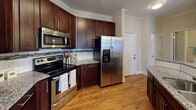 Located at 315 Pisgah Church Rd in Greensboro, NC, this single-floor residence offers a well-designed layout that balances comfort and functionality. The open-concept living and dining area features warm hardwood-style flooring, crown molding, and a ceiling fan, with a glass-paneled entry door that invites natural light into the space. Louvered closet doors and track lighting add practical and stylistic detail to the living area.

The kitchen is a standout feature, showcasing rich dark-wood cabinetry with sleek hardware, granite countertops, a classic subway tile backsplash with mosaic accents, and a full suite of stainless steel appliances including a range, over-the-range microwave, and French door refrigerator. A peninsula with pendant lighting provides an ideal space for casual dining or entertaining.

The bedrooms are carpeted for comfort and include ceiling fans and windows that offer views of the surrounding neighborhood, providing a bright and airy atmosphere. The bathrooms are well-finished, featuring dark wood vanities with granite countertops, hardwood-style tile flooring, and tiled tub-shower combinations, creating a clean and cohesive aesthetic throughout.