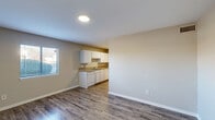 This efficiently designed single-floor unit offers a thoughtful layout that maximizes every square foot. The open-concept living, dining, and kitchen area forms the heart of the space, creating a seamless flow for everyday living. Durable hardwood-style flooring runs throughout, complemented by neutral beige walls and clean white trim that lend a bright, cohesive aesthetic.

The kitchen is well-appointed with white cabinetry — both upper and lower — providing ample storage, paired with a neutral-toned countertop, a stainless steel sink, a dishwasher, and an electric range. A window in the main living area invites natural light, enhancing the open feel of the space.

The bedroom is a comfortable, private retreat with a window fitted with blinds, allowing for adjustable natural light. A dedicated closet provides convenient storage. The bathroom features a white vanity with an integrated sink and countertop, a large mirror, and hardwood-style flooring that mirrors the rest of the unit.

Additional highlights include a patio that extends the living space outdoors. The unit's clean, neutral palette and functional design make it a practical and inviting space suitable for a variety of living needs.