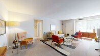 This single-floor residence showcases a cohesive mid-century modern design throughout its thoughtfully arranged living spaces. The generously sized living room serves as the heart of the home, featuring plush carpeting, neutral walls, and ample room for a full seating arrangement. Large windows allow natural light to filter in, creating a bright and welcoming atmosphere. The space flows seamlessly into a dedicated dining area, which makes a bold design statement with a deep navy accent wall, warm hardwood flooring, and room for a full six-seat dining table — ideal for entertaining. The galley-style kitchen is efficiently laid out with cream cabinetry, dark granite-style countertops, a full suite of white appliances including a gas range and refrigerator, and warm hardwood flooring that ties the space together. Two well-proportioned bedrooms offer carpeted floors, natural light through large windows with vertical blinds, and ample space for both sleeping and working areas. The full bathroom is finished in clean white tiling and includes a shower-tub combination with a white vanity and built-in storage. Throughout the residence, a warm and curated mid-century modern palette of mustard yellows, rich reds, and deep blues lends a stylish and inviting character to every room.