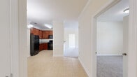 Located at 117 Winter Forest Dr in Candler, NC, this single-floor, three-bedroom, three-bathroom home offers a practical and comfortable layout. The kitchen is a standout feature, equipped with rich cherry wood cabinetry, granite countertops, black appliances including a range and built-in microwave, and light tile flooring. It opens to the dining area, which is accented by an elegant chandelier and a granite-topped breakfast bar, creating a seamless space for dining and entertaining. Crown molding is present throughout, adding a refined architectural detail to the interiors. The living areas feature plush carpeting and ceiling fans, with windows that invite natural light and outdoor views of the surrounding greenery. The primary bedroom offers a walk-in closet with wire shelving for organized storage. The bathrooms are finished with matching cherry vanities, granite countertops, and tile flooring, with one bathroom featuring a full soaking tub and shower combination. A dedicated laundry room includes washer/dryer hookups and overhead wire shelving for added utility. The bedrooms are carpeted and well-lit by natural light through sizable windows. Overall, the home presents a cohesive, neutral palette with warm wood tones and consistent finishes throughout.