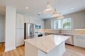 This contemporary 1,040 square foot apartment in Tampa, FL offers a harmonious blend of style and functionality. The heart of the home is a stunning kitchen, featuring crisp white cabinetry, stainless steel appliances, and a spacious island with pendant lighting. Large windows allow natural light to flood the space, enhancing the airy feel created by the light wood flooring throughout.

The two bedrooms are generously sized, with the primary bedroom boasting 140 square feet of space. Both bathrooms are thoughtfully designed with modern fixtures and finishes. The apartment includes two closets, one of which showcases a custom organization system with shelving and hanging space.

The open floor plan creates a seamless flow between living areas, ideal for both relaxation and entertaining. Ceiling fans in the bedrooms provide additional comfort. The neutral color palette throughout allows for easy personalization.

This Unit 207 at 5301 W Tyson Ave combines the convenience of apartment living with the aesthetics of a high-end home, offering a perfect balance of comfort and style in its single-floor layout.