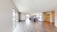 Located at 219 W Wayne St in the heart of Fort Wayne, Indiana, this contemporary single-level residence offers three bedrooms and three bathrooms across a thoughtfully designed floor plan. The open-concept living and kitchen area serves as the centerpiece of the home, bathed in natural light from expansive floor-to-ceiling windows that frame sweeping views of the surrounding cityscape. A sliding glass door leads to a private balcony, seamlessly blending indoor and outdoor living. The sleek kitchen is appointed with white upper cabinetry, contrasting dark lower cabinets, granite countertops, stainless steel appliances including a French door refrigerator, and a large center island ideal for dining and entertaining. Hardwood-style flooring flows throughout the main living areas and into the bedrooms, lending warmth and cohesion to the space. The generously sized primary bedroom features large windows with city views and ample closet space. Additional bedrooms are well-proportioned, each with closet storage. The bathrooms are clean and modern, featuring sliding glass-door showers. A dedicated laundry room with full-size washer and dryer adds everyday convenience. The hallways are bright and well-lit, completing this polished, move-in-ready urban residence.