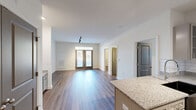 Located at 8700 Seeing Trail Rd in Wake Forest, NC, this single-floor, 2-bedroom, 2-bathroom residence offers a well-organized and functional layout. The open-concept living and kitchen area is anchored by rich wood-tone flooring that flows throughout the space. French doors in the living room flood the area with natural light and provide views of the surrounding tree-lined landscape. Track lighting adds a modern touch to both the living and kitchen areas.

The kitchen features granite countertops, gray cabinetry, a white subway tile backsplash, and stainless steel appliances including a refrigerator, range, and over-the-range microwave. A kitchen island with additional counter space enhances the functionality of the cooking area.

The spacious primary bedroom includes a ceiling fan and access to a generously sized walk-in closet outfitted with wire shelving and hanging systems for organized storage. The second bedroom also features a ceiling fan and its own closet. Both bathrooms are finished with wood-look flooring, and one includes a full tub-shower combination. A dedicated laundry area adds everyday convenience. The unit also benefits from outdoor views of mature trees and a well-maintained community setting.