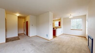 Located at 1614 Kempton St SE in Olympia, Washington, this 2-bedroom, 1-bathroom single-floor home offers a well-organized and functional layout. The open living room is a welcoming centerpiece, featuring soft neutral carpet, a fireplace, and windows that fill the space with natural light and views of the surrounding neighborhood. The layout flows seamlessly into a pass-through kitchen, which is equipped with warm wood cabinetry, dark countertops, tile flooring, recessed lighting, and black appliances including a refrigerator and range. A breakfast bar connects the kitchen to the main living area, making it ideal for everyday use. The primary bedroom is generously sized, featuring large windows that invite natural light and a sliding closet. The second bedroom also offers carpeted flooring, natural light, and its own closet. The full bathroom is well-appointed with a tiled tub-shower surround, wood vanity with a granite-style countertop, an integrated sink, and tile flooring. Additional highlights include a hallway with multiple closets for ample storage, a private balcony, and consistent warm-toned wood trim throughout. The overall ambiance is clean, bright, and move-in ready.