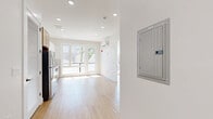 Located at 40 Lembeck Ave in Jersey City, NJ, this two-bedroom unit on the second floor offers a thoughtfully designed layout with a clean, contemporary aesthetic throughout. Light hardwood flooring flows seamlessly across the entire space, complementing the crisp white walls and recessed lighting that create a bright, airy atmosphere.

The kitchen is a standout feature, outfitted with a combination of white gloss upper cabinets and warm natural wood lower cabinetry, a subway tile backsplash, and a full suite of stainless steel appliances including a gas range, microwave, refrigerator, and dishwasher. A large window in the kitchen frames views of the surrounding neighborhood and allows abundant natural light to pour in.

The living area benefits from additional windows and a glass door that further enhance the open, sunlit feel of the space. A wall-mounted ductless HVAC unit provides efficient climate control throughout.

The primary bedroom offers a comfortable footprint with a window for natural light, while the second bedroom features hardwood floors and a window as well. Both rooms are served by clean-lined, white-paneled doors with black hardware accents that add a modern touch. The unit presents a fresh, move-in ready condition well-suited for urban living in Jersey City.