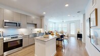 Located at 9302 Fry Rd in Cypress, TX, this thoughtfully designed one-bedroom, one-bathroom residence offers a clean, modern aesthetic throughout its efficiently organized single-floor layout. Light wood-tone flooring flows seamlessly across the entire space, complemented by crisp white walls and recessed lighting that create a bright, welcoming atmosphere.

The open-concept kitchen is a standout feature, showcasing contemporary flat-panel cabinetry in a warm taupe finish, granite countertops, a subway tile backsplash, and a full suite of stainless steel appliances including a refrigerator, range, microwave, and dishwasher. A central island with bar seating connects the kitchen to the combined dining and living area, which is bathed in natural light from multiple windows and features a ceiling fan overhead. A private exterior door in the living area adds convenient access to the outdoors.

A hallway off the main living space leads to the bedroom, which offers two windows, a ceiling fan, and wood-look flooring. An adjacent walk-in closet provides ample storage with dual hanging rods and shelving. The full bathroom features a granite-topped vanity with a taupe cabinet, large-format tile surround in the tub/shower combination, and wood-look flooring consistent with the rest of the home.