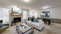 This single-story residence on W 78th Street in Tulsa, Oklahoma offers a thoughtfully designed layout that connects living, dining, and kitchen spaces in an open, functional flow. The living room serves as the focal point of the home, anchored by a elegant stone-surround fireplace and flanked by multiple windows fitted with blinds and sheer curtains that allow generous natural light. Plush carpeting throughout the living and dining areas adds warmth, while the open floor plan provides a comfortable sense of space.

The kitchen is well-equipped, featuring warm-toned raised-panel cabinetry that extends to the upper walls for ample storage, granite-style countertops, and tile flooring. A breakfast bar connects the kitchen to the main living area, enhancing the home's open feel.

Both bedrooms are carpeted and equipped with ceiling fans, offering a comfortable, restful environment. Each room includes windows with natural light and space for substantial furniture. The bathroom features tile flooring, a wide vanity with raised-panel cabinetry, a large mirror, and a well-lit vanity strip, providing a clean and functional space. Overall, the home presents a warm, cohesive aesthetic throughout.
