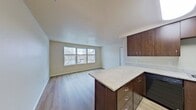 This 460 square foot apartment in Vancouver, WA offers a thoughtful layout maximizing space and functionality. The heart of the home is an open-concept kitchen and living area, showcasing rich, dark wood cabinetry contrasted by light granite countertops. The kitchen is equipped with modern black appliances and ample storage space.

The single bedroom, measuring 130 square feet, provides a cozy retreat with a large window allowing natural light to flood the space. The bathroom features a granite-topped vanity matching the kitchen's aesthetic, with a combination bathtub and shower.

Throughout the apartment, warm-toned laminate flooring creates a cohesive look, while white walls and trim contribute to a bright, airy atmosphere. Large windows in the living area and bedroom offer views of the surrounding neighborhood and fill the space with natural light.

The apartment's efficient design includes closet space with sliding doors for maximized storage. Recessed lighting and a central ceiling fixture in the bedroom provide layered illumination options.

Located at 5302 NE 72nd St in Vancouver, this single-floor apartment offers a perfect blend of modern amenities and compact living, ideal for those seeking a low-maintenance lifestyle without sacrificing comfort or style.