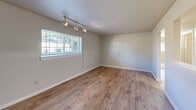 Located at 100 Kimball Ave in Salem, Virginia, this 2-bedroom, 1-bathroom unit offers a practical and well-organized single-floor layout. The living room features warm wood-look laminate flooring and track lighting overhead, with a wide window that brings in natural light and views of the surrounding greenery. The kitchen is efficiently laid out with light wood cabinetry, dark countertops, and a full suite of white appliances including a refrigerator, dishwasher, electric range, and over-the-range microwave. Both the kitchen and living areas share the same durable laminate flooring, creating a cohesive feel throughout the common spaces. The two bedrooms are carpeted and offer a comfortable, quiet atmosphere. Each room features a ceiling fan with light, a closet, and a window that admits natural light. The primary bedroom provides a generous amount of space. The bathroom includes a full soaking tub and shower combination with clean white tile surround, complemented by a louvered closet door for added storage. Neutral wall tones throughout the unit create a versatile backdrop suitable for a variety of décor styles. The layout flows logically, making efficient use of the available square footage.