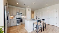 This thoughtfully designed 2-bedroom, 2-bathroom residence offers a comfortable and functional single-floor layout with contemporary finishes throughout. Light wood-look flooring flows seamlessly across the entire home, creating a cohesive and airy aesthetic.

The open-concept kitchen is a standout feature, boasting granite countertops, gray shaker-style cabinetry, white subway tile backsplash, stainless steel appliances, and a central island with bar seating — ideal for both cooking and casual dining.

The spacious living room is bathed in natural light from multiple large windows with views to the outdoors, and features a ceiling fan overhead, creating a bright and inviting atmosphere for everyday living.

The primary bedroom offers generous proportions with a ceiling fan, large windows, and direct access to an en-suite bathroom. The primary bathroom includes a granite-topped vanity with gray cabinetry and a walk-in closet with built-in wire shelving. The second bedroom is equally comfortable, also featuring a ceiling fan and large window. The second bathroom includes a tub-shower combination with elegant tile surround.

Both bedrooms are connected by a clean, well-lit hallway that ties the layout together. The two dedicated closets provide ample storage throughout the home.