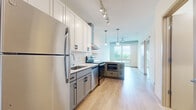 Located at 657 22nd Avenue Northeast in Minneapolis, MN, this one-bedroom, one-bathroom unit offers a thoughtfully designed single-floor layout that maximizes every square foot. Light hardwood flooring runs throughout the space, creating a warm and cohesive aesthetic from room to room.

The kitchen is a standout feature, outfitted with a full suite of stainless steel appliances including a refrigerator, electric range with a stainless hood vent, dishwasher, and built-in microwave. Crisp white upper cabinetry is paired with gray lower cabinets and light countertops, while track lighting above and pendant lights near the living area provide layered illumination. The kitchen opens directly toward the living area, which benefits from large floor-to-ceiling windows that invite abundant natural light and offer views of the surrounding greenery.

The bedroom is a bright, clean space with a large window framing outdoor views and access to a dedicated closet with wire shelving for organized storage. The bathroom is conveniently positioned adjacent to the closet area, featuring hardwood-style flooring consistent with the rest of the unit.

The overall ambiance is modern, clean, and functional, well-suited for those seeking a contemporary urban living space in the Northeast Minneapolis neighborhood.