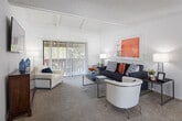 Located at 15123 Brookhurst St in Westminster, CA, this single-story residence offers a well-organized and functional layout across several distinct living areas. The living room is a standout space, featuring vaulted ceilings with exposed beams, plush carpeting, and a sliding glass door that opens to a private patio, allowing natural light to fill the room. A separate dining area adjoins the living space and includes hardwood-style flooring, a ceiling fan, and a window overlooking the exterior. The kitchen is efficiently designed with white cabinetry, granite-style countertops, a double sink, a dishwasher, and a range, along with a large window that brings in additional natural light. The two bedrooms are carpeted and feature textured ceilings, large windows with vertical blinds, and sliding mirrored closet doors offering ample storage. The primary bedroom is generously sized with easy access to the full bathroom. The bathroom is cleanly appointed with white cabinetry, a granite-style vanity countertop, a tub-shower combination, and a large mirror with overhead lighting. Throughout the home, a consistent neutral color palette creates a cohesive and comfortable atmosphere.