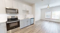 This thoughtfully laid-out one-bedroom, one-bathroom residence in Jacksonville, FL (32258) offers a clean, modern aesthetic throughout. Light-toned luxury vinyl plank flooring runs through the main living areas, complementing the bright white walls and recessed lighting that keep the space feeling open and airy. The open-concept layout seamlessly connects the living room, dining area, and kitchen, with a ceiling fan and natural light from front-facing windows enhancing the welcoming atmosphere. The kitchen is well-appointed with white shaker-style upper cabinets, light blue lower cabinets, quartz countertops, a stainless steel refrigerator, electric range, microwave, and dishwasher — all Whirlpool appliances. The bedroom features plush carpeting, a ceiling fan, a window with outdoor views, and access to a generously sized walk-in closet with wire shelving. Two additional closets provide excellent storage throughout. The bathroom offers a full tub-shower combination, a white vanity with stone countertop, and wood-look flooring. A dedicated laundry room with a full-size Whirlpool washer and dryer adds everyday convenience to this efficiently designed home.