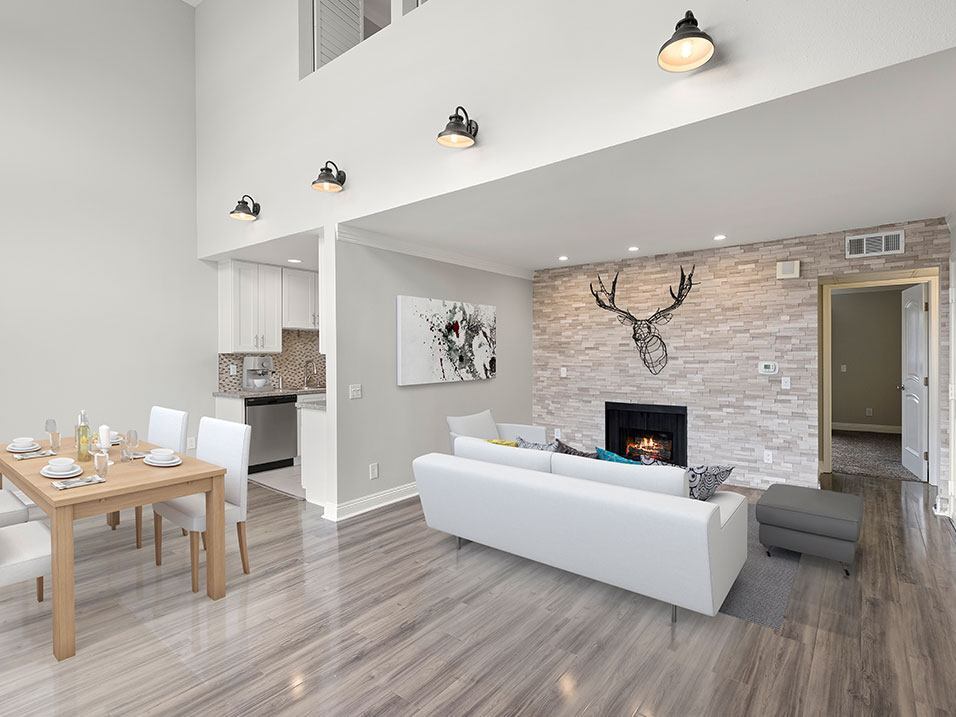 Living room with decorative stone wall and view of loft overhead. - Hughes Regency