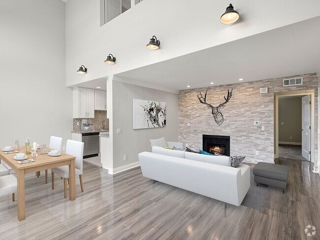 Living room with decorative stone wall and view of loft overhead. - Hughes Regency